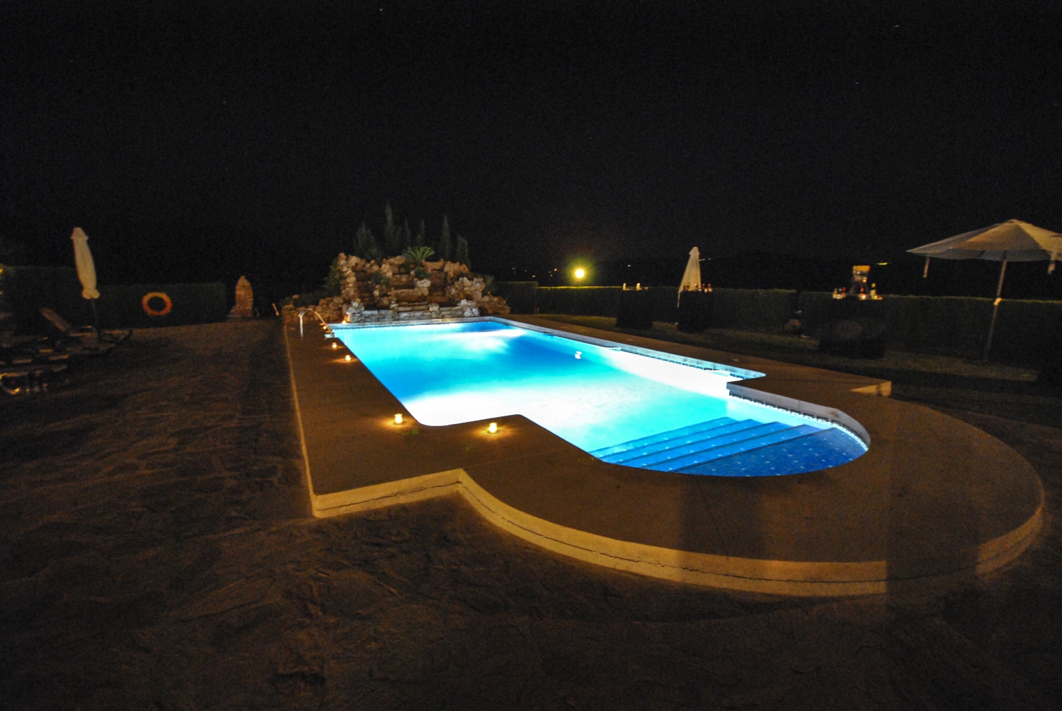 La Piscina de Cortijo Las Monjas se viste de noche para la fiesta flamenca celebrada en los jardines. Valle del Sabar, Alta Axarquía. Málaga, Andalucía, España