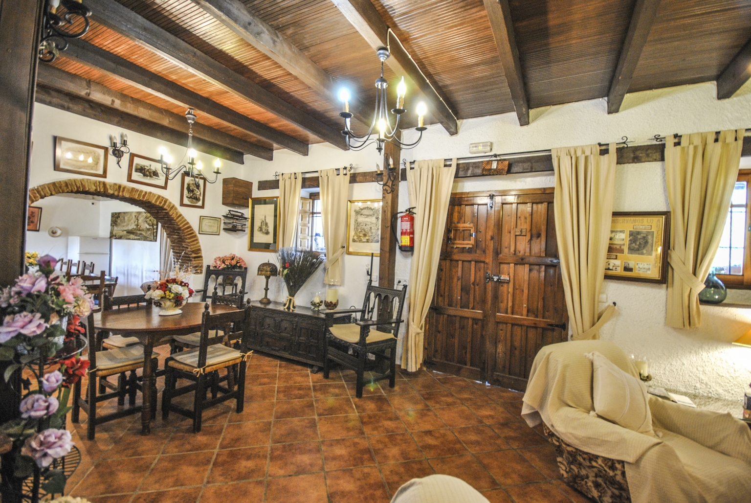 Salón comedor común con chimenea y pequeña cocina, para tus reuniones familiares o empresariales, en Cortijo Las Monjas. Un lugar acogedor en la Alta Axarquía, interior de la Costa del Sol, provincia de Málaga, Andalucía