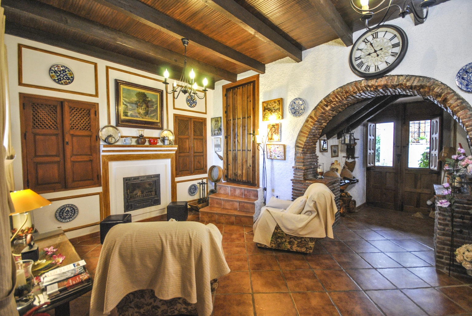 Salón comedor común con chimenea y pequeña cocina, para tus reuniones familiares o empresariales, en Cortijo Las Monjas. Un lugar acogedor en la Alta Axarquía, interior de la Costa del Sol, provincia de Málaga, Andalucía